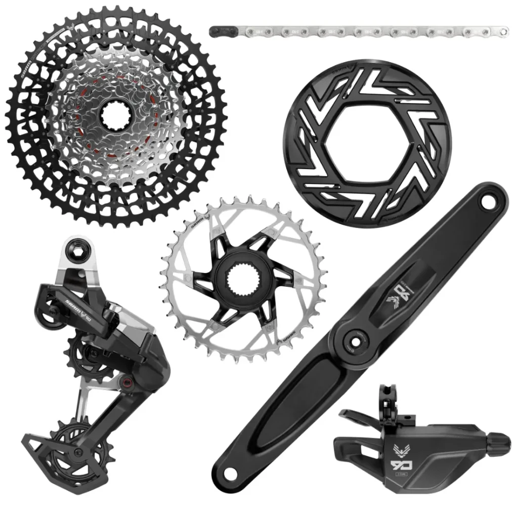 Los componentes de una transmisión de bicicleta, incluyendo el cassette SRAM Eagle, el plato, el desviador, la cadena, la palanca de cambios y la biela, se presentan sobre un fondo blanco. La configuración resalta la precisión de los cambios mecánicos analizados para un rendimiento óptimo en ciclismo.