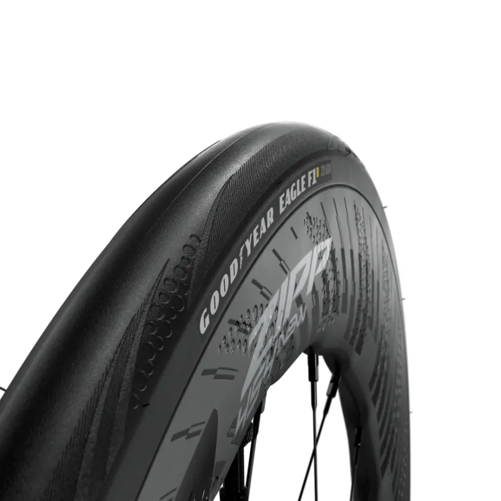 Vista de cerca de un neumático de bicicleta Goodyear Eagle F1 montado en una rueda de carbono Zipp 2026, diseñada para rodar más rápido, sobre un fondo blanco.