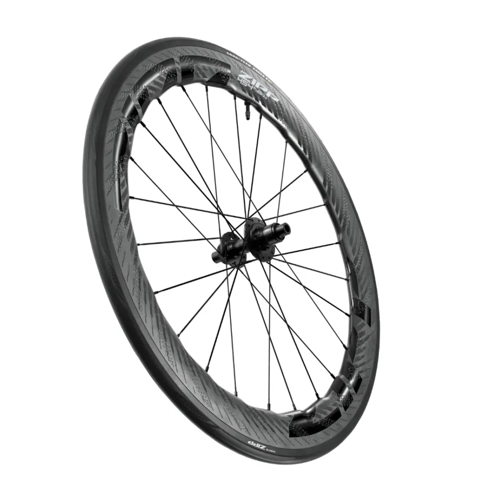 Se muestra una rueda de bicicleta de fibra de carbono Zipp 2026 con una llanta de sección profunda, radios planos y un buje central en ángulo sobre un fondo blanco, ideal para quienes buscan rodar más rápido.