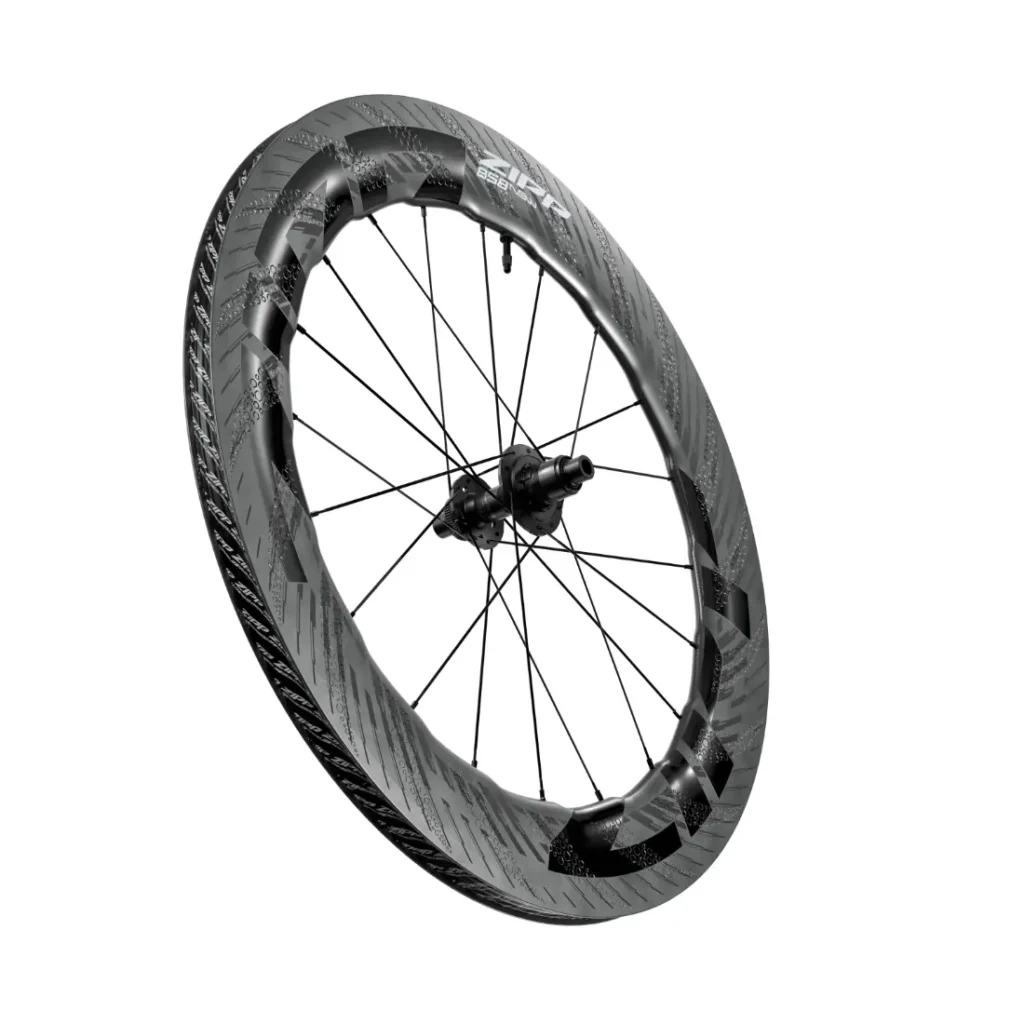 Una rueda de bicicleta Zipp 2026 de fibra de carbono con llanta aerodinámica de sección profunda y radios negros, diseñada para rodar más rápido, fotografiada sobre un fondo blanco.