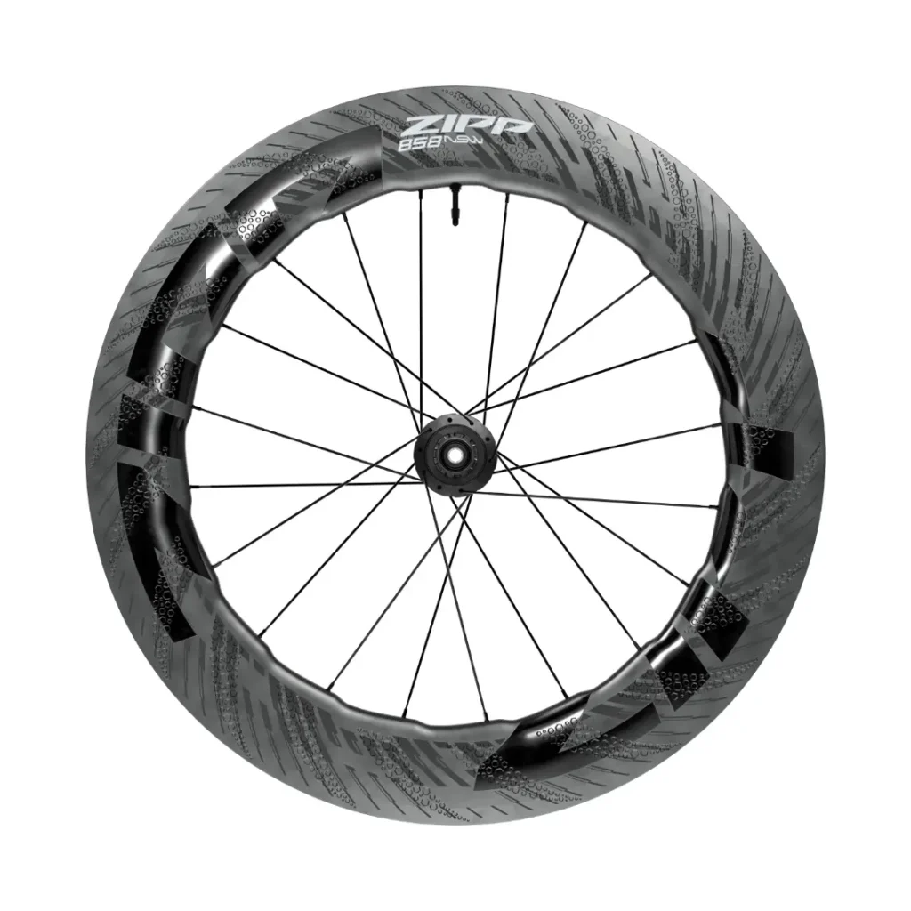 Una rueda de bicicleta de fibra de carbono con llanta aerodinámica de sección profunda, radios negros y la marca Zipp 858 NSW en la parte superior, diseñada para rodar más rápido. Descubre la innovación que anticipa la próxima evolución de Zipp 2026.