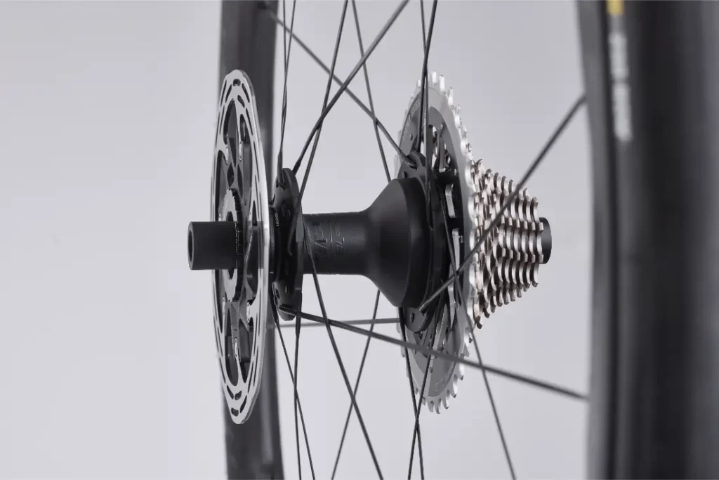 Vista de cerca de una rueda de bicicleta Zipp 2026 que muestra el cassette, el rotor del freno de disco, el buje y los radios sobre un fondo simple, diseñado para rodar más rápido con un rendimiento avanzado.