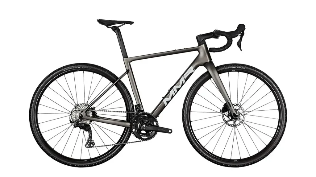 Se muestra una bicicleta de ruta MMR Simun de color negro mate con manillar bajo, frenos de disco y neumáticos delgados en una vista lateral sobre un fondo blanco.