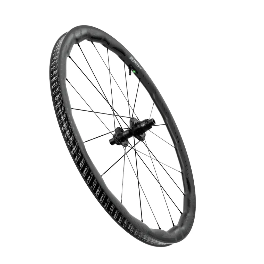 Una sola rueda de bicicleta Zipp 2026 negra con radios, mostrada en ángulo sobre un fondo blanco liso, diseñada para ayudarte a rodar más rápido.
