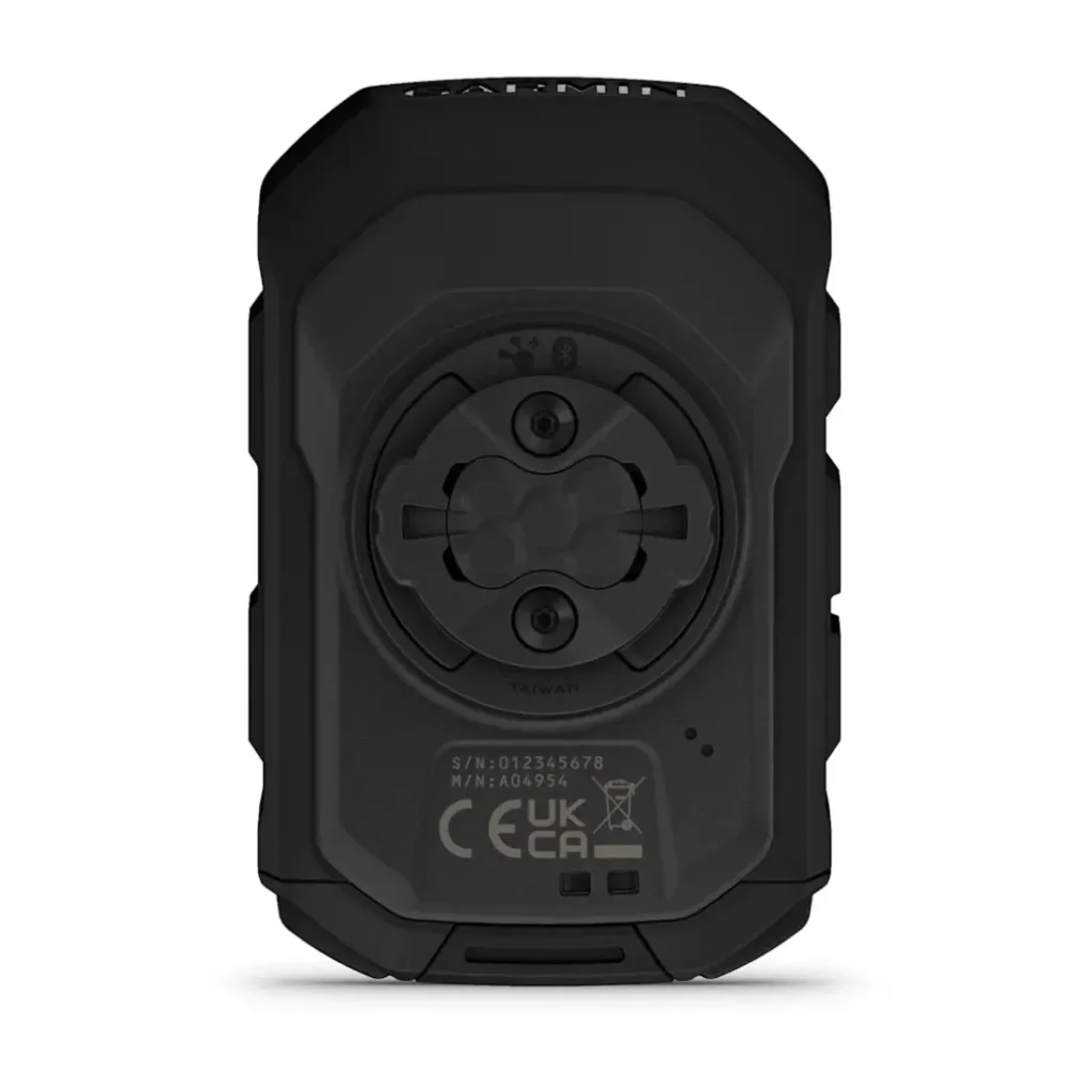 Vista trasera de un ciclocomputador Garmin Edge MTB negro que muestra una interfaz de montaje circular, el número de serie y las marcas de certificación.