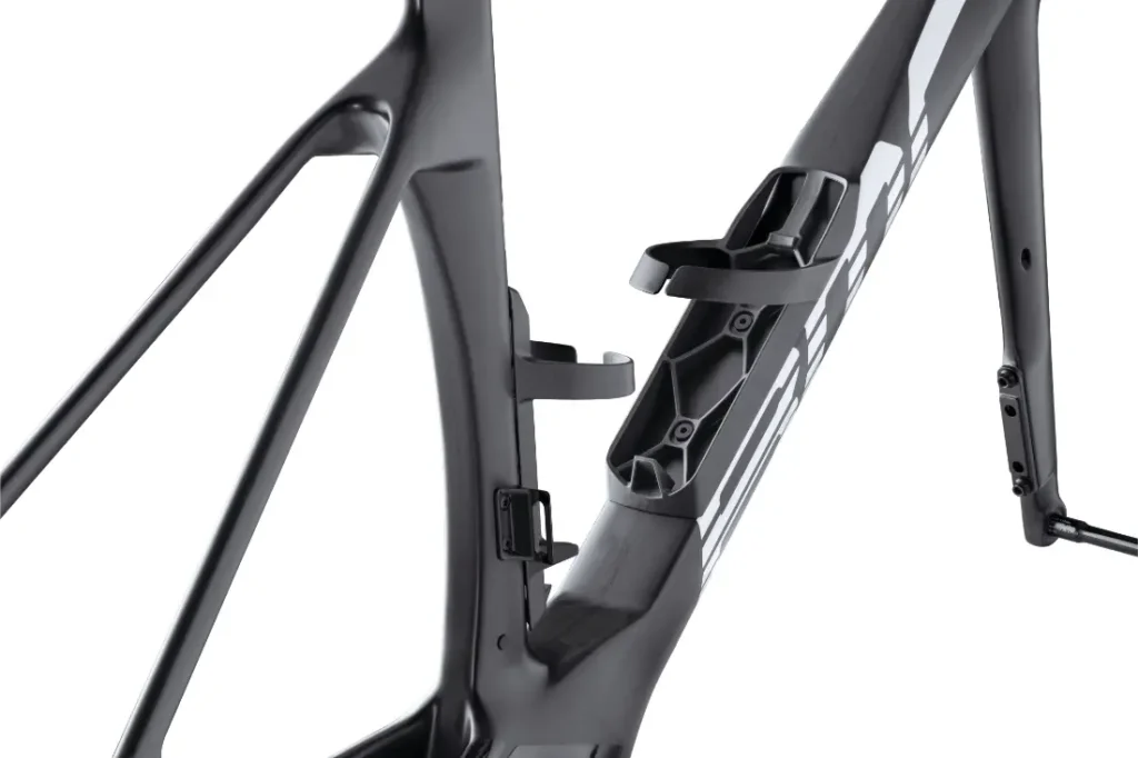 Vista de cerca de un cuadro de bicicleta BMC VAR0 que muestra su acabado negro mate, soportes para portabotellas y puertos de enrutamiento de cables internos.