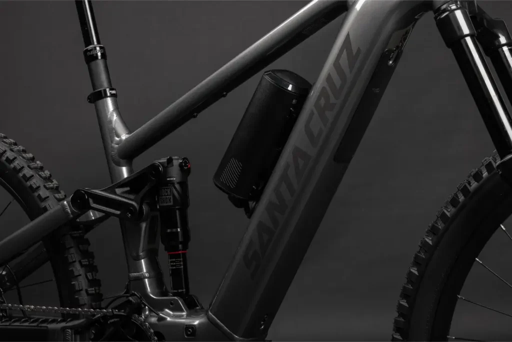 Primer plano de un cuadro de bicicleta de montaña Santa Cruz Vala AL negro y gris en aluminio, destacando la suspensión trasera y un accesorio cilíndrico montado en el interior del triángulo del cuadro.