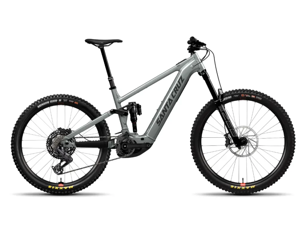 Una bicicleta de montaña Santa Cruz Vala AL gris mate con suspensión total, fabricada en aluminio, con frenos de disco, neumáticos gruesos, manillar plano y la marca "Santa Cruz" en el cuadro.