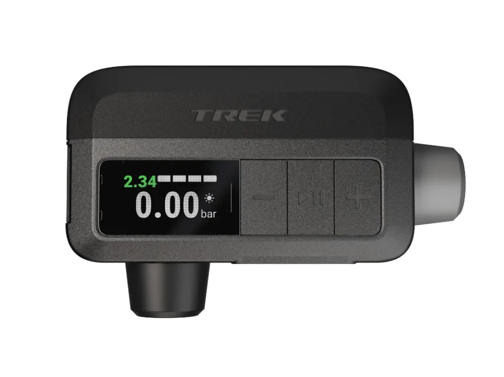 Un manómetro digital para neumáticos que muestra 2,34 con botones de control y un accesorio de boquilla, ideal para el inflado de ruedas, sobre fondo blanco.
