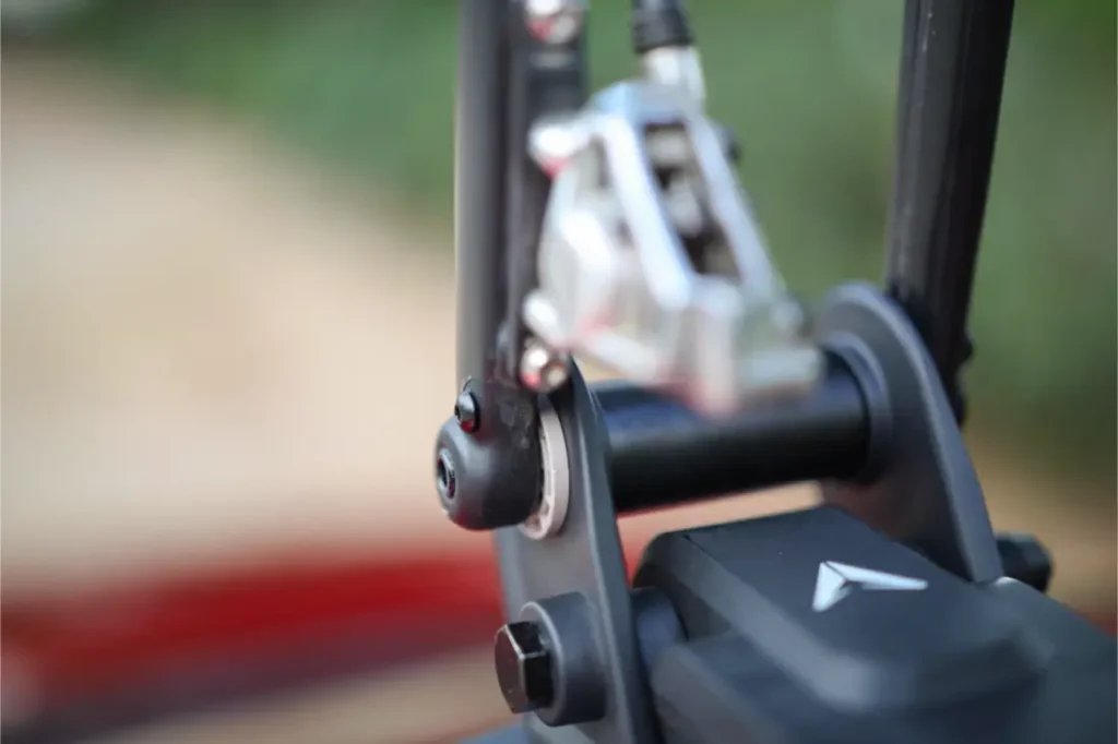 Primer plano de un componente mecánico de una bicicleta, que muestra parte de la pinza de freno, un tornillo y una sección del cuadro, perfecta para fijarla con un soporte Allen Smart Suction Bike Rack.