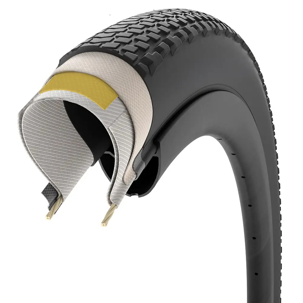 Sección transversal de un neumático de bicicleta Pirelli Cinturato Gravel que muestra múltiples capas internas, bandas de rodadura en la superficie exterior y dos hilos de talón en la base: una opción avanzada para los entusiastas de los neumáticos de grava.