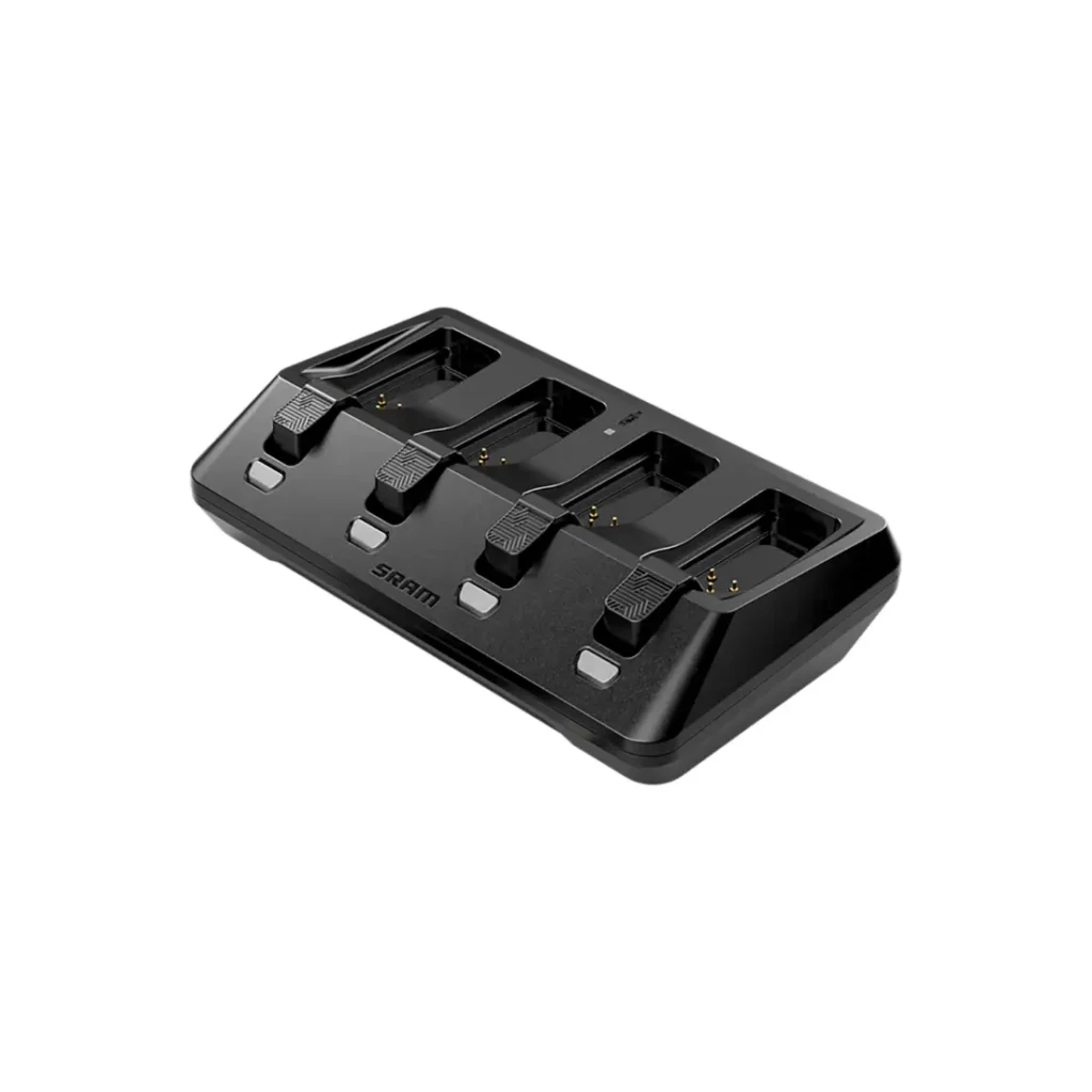 Cargador de batería SRAM negro con cuatro ranuras de carga, vista en ángulo sobre fondo blanco. Descubre las novedades SRAM febrero 2026 en innovadores accesorios para tus dispositivos.
