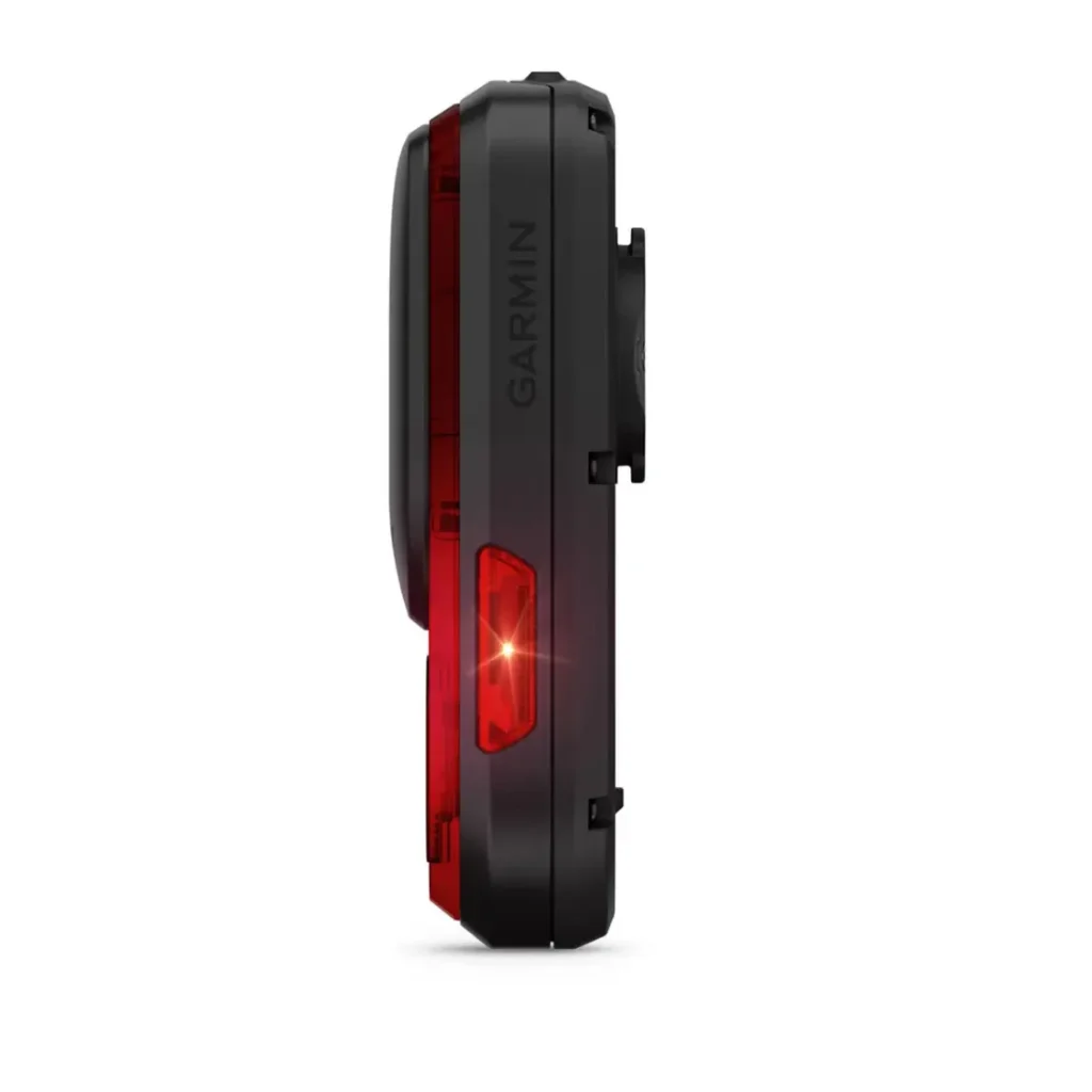 Vista lateral de una luz trasera de ciclismo Garmin Varia RearVue 820 negra con lente iluminada en rojo, aislada sobre fondo blanco.