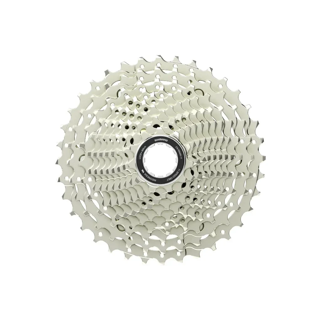 Casete plateado de bicicleta Shimano Tiagra R4000 con múltiples piñones dispuestos en forma circular, visto desde arriba sobre fondo blanco.
