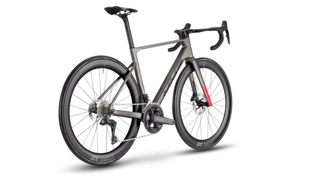 Una moderna bicicleta de carretera MMR Aelion con cuadro aerodinámico, manillar rebajado, frenos de disco y ruedas DT Swiss de sección profunda, vista desde la parte trasera izquierda sobre fondo blanco.