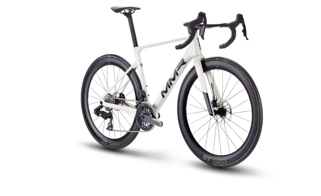 Bicicleta de carretera MMR Aelion blanca con manillar rebajado, ruedas DT Swiss de sección profunda y la marca acento asturiano MMX en el cuadro, vista desde un ángulo trasero, una pieza destacada en cualquier colección de bici total.