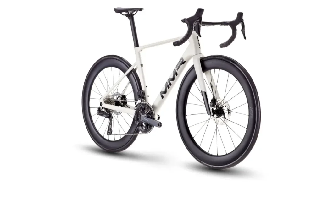 Bicicleta de carretera MMR Aelion SL blanca con ruedas negras de sección profunda, manillar rebajado y diseño de cuadro aerodinámico, vista en ángulo desde el lado frontal izquierdo: una auténtica bici total para los entusiastas del rendimiento.