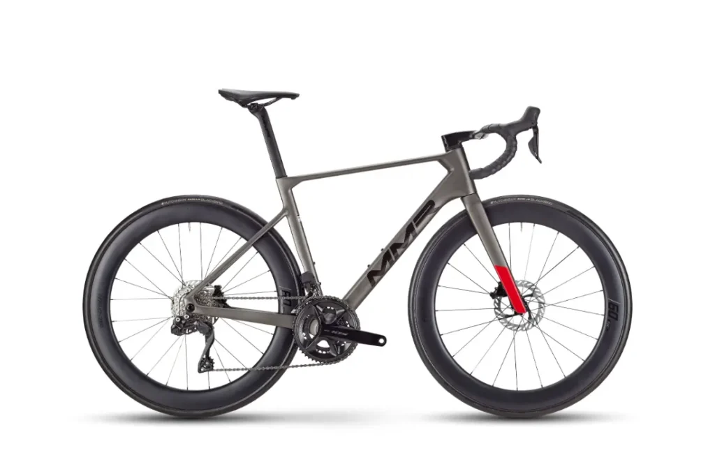 Una moderna bicicleta de carretera MMR Aelion con cuadro metálico, frenos de disco, ruedas de sección profunda y un acento rojo en la horquilla delantera, mostrada sobre un fondo blanco, perfecta para ciclistas que buscan una bicicleta total con acento asturiano.
