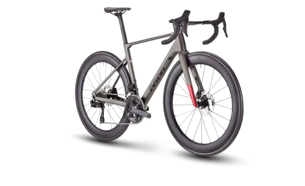 Una moderna bicicleta de carretera MMR Aelion con cuadro gris mate, manillar rebajado, frenos de disco y ruedas aerodinámicas de sección profunda, vista desde un ángulo trasero sobre fondo blanco. Perfecta para quienes buscan rendimiento y estilo con total confianza en la bicicleta.