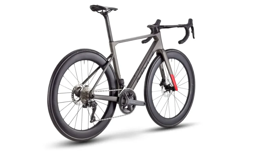 Bicicleta de carretera MMR Aelion de color negro mate con manillar rebajado, ruedas de sección profunda y un acento rojo en la horquilla delantera, vista desde un ángulo lateral trasero sobre un fondo blanco.