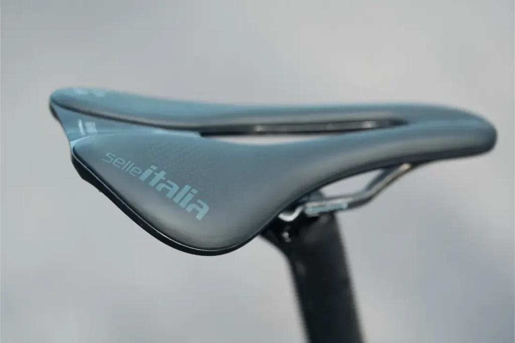 Primer plano de un sillín de bicicleta Selle Italia negro con un diseño elegante y ergonómico, montado en una tija MMR Aelion SL sobre un fondo neutro. Ideal para entusiastas de la bici total.