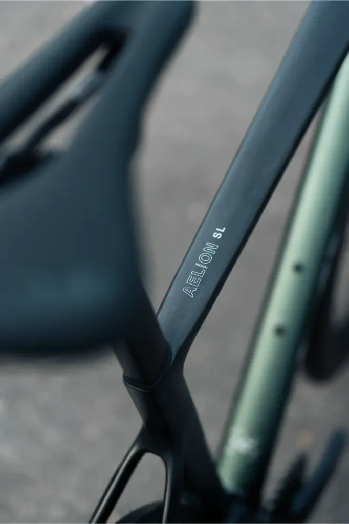 Primer plano de un cuadro de bicicleta MMR Aelion SL rotulado "AEROLOW SL" cerca de la tija del sillín, con parte del sillín y la cubierta visibles: una auténtica bici total.