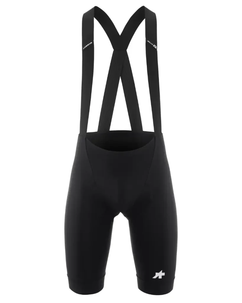 Culotte negro con tirantes y un pequeño logotipo blanco en la pernera izquierda, el ASSOS MILLE GT S11 ofrece confort inteligente y marca una evolución real en ropa de alto rendimiento, sobre un fondo blanco liso.