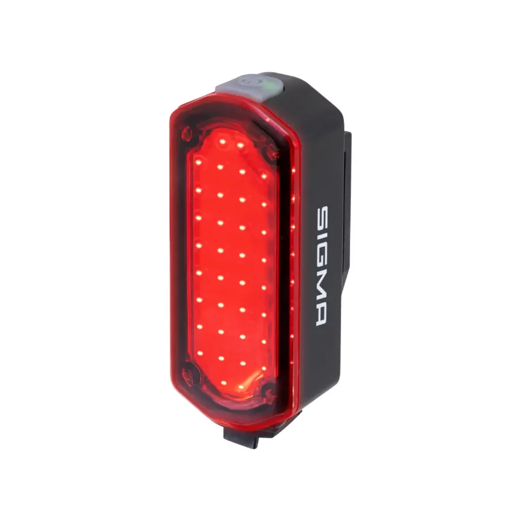 Piloto trasero de bicicleta SIGMA NYTE CLIP negro rectangular con múltiples luces LED rojas iluminadas, mostrado sobre un fondo blanco liso.