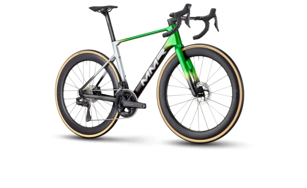 La MMR Aelion SL es una moderna bicicleta de carretera con cuadro verde, blanco y negro, manillar rebajado, frenos de disco y neumáticos de pared color tostado sobre ruedas de sección profunda, que se muestra sobre un fondo blanco: perfecta para cualquier entusiasta de la bici total.