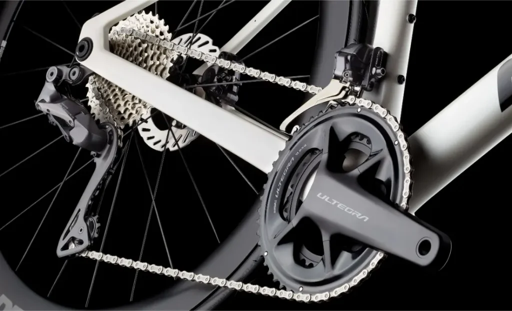 Primer plano de una transmisión de bicicleta con plato, cadena, cambio trasero, casete y freno de disco trasero Shimano Ultegra en la MMR Aelion SL, que destaca la precisión de sus componentes mecánicos.