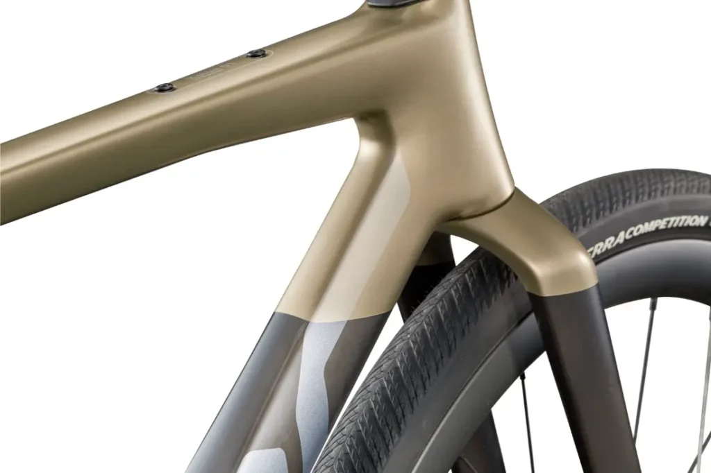 Primer plano del cuadro y la rueda trasera de una bicicleta rápida moderna, que muestra un diseño elegante y un acabado metálico liso con patrones de colores geométricos inspirados en la BMC Kaius 01.