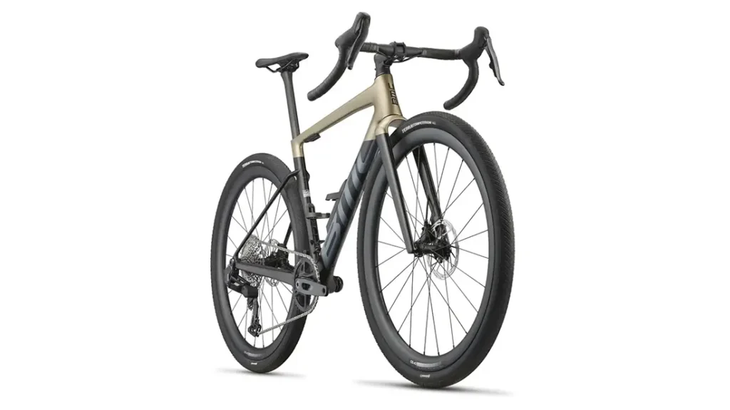 Una moderna BMC Kaius 01 para gravel con manillar rebajado, neumáticos anchos y cuadro dorado y negro mate, vista desde el ángulo frontal izquierdo sobre fondo blanco: una bicicleta rápida para cualquier aventura.