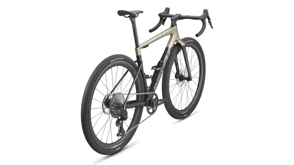 Una bicicleta moderna actual con manillar caído, neumáticos grandes y cuadro de color claro, vista desde el ángulo posterior izquierdo sobre fondo blanco.