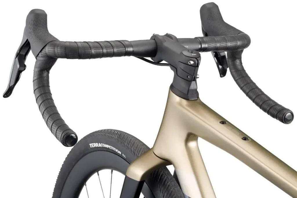 Primer plano de la BMC Kaius 01, una bicicleta rápida y actual, en la que destacan el moderno manillar, las manetas de freno y el cuadro delantero con un visible neumático "TERRA COMPETITION".