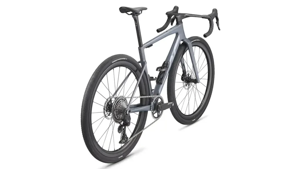 Una moderna BMC Kaius 01 gris para gravel con manillar rebajado, frenos de disco y neumáticos anchos, vista desde la parte trasera derecha sobre fondo blanco: una bicicleta rápida para cualquier terreno.