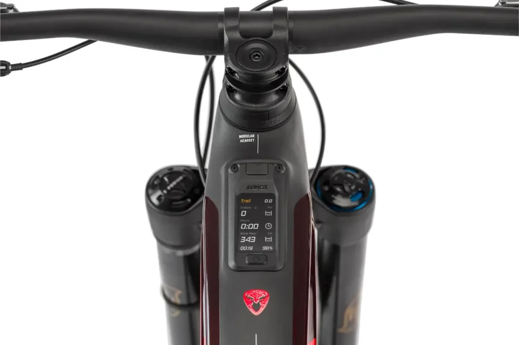 Vista superior en primer plano del manillar y la horquilla delantera de una bicicleta Rotwild R.EXC, con una pantalla digital que muestra datos y ajustes de la ruta, lista para competir, sobre un fondo blanco.