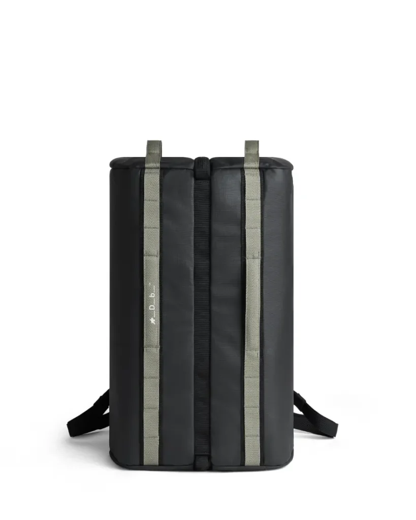 Una mochila rectangular negra con dos correas verdes verticales y tirantes negros, que se muestra en posición vertical sobre un fondo blanco. Diseñada para ciclistas, esta pieza ASSOS x Db es perfecta para tus esenciales del sistema de viaje.