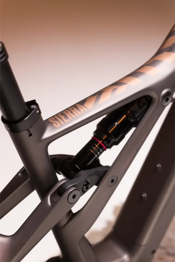 Primer plano de un cuadro Fantic Sierra e-MTB, destacando la suspensión trasera y el acabado mate con el nombre de la marca a la vista, propulsado por Bosch CX Gen5.