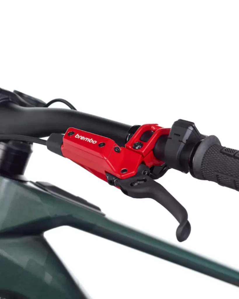 Primer plano de un manillar de bicicleta con una maneta de freno Brembo GR-PRO roja acoplada, que muestra el agarre y parte del cuadro e-MTB, perfecto para los ciclistas que buscan prestaciones frenos para gravedad.