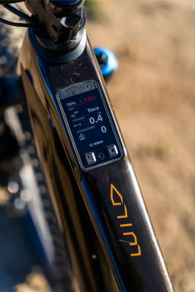 Primer plano de un potente cuadro de bicicleta con una pantalla digital Bosch Performance Line CX que muestra el porcentaje de batería, el modo, la velocidad, el nivel de asistencia y los datos del recorrido; el logotipo "WILD" es claramente visible en el cuadro.