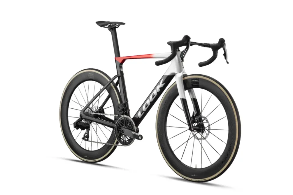 Una bicicleta de carretera con manillar de carretera, ruedas de perfil alto, un cuadro en blanco y negro con detalles en rojo y la marca «LOOK» en el tubo diagonal: se trata de la LOOK 795 Blade RS 3, perfecta para recorrer rutas desde Nevers hasta Arma Total.