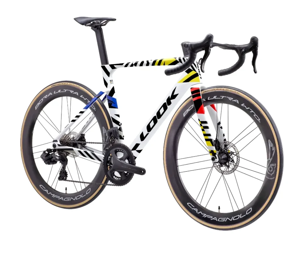 Una bicicleta de carretera LOOK 795 Blade RS 3 con un cuadro blanco con detalles en negro, amarillo, rojo y azul, ruedas de perfil alto, el logotipo «LOOK» en el cuadro y «Campagnolo» en las ruedas: toda una atracción en Nevers.