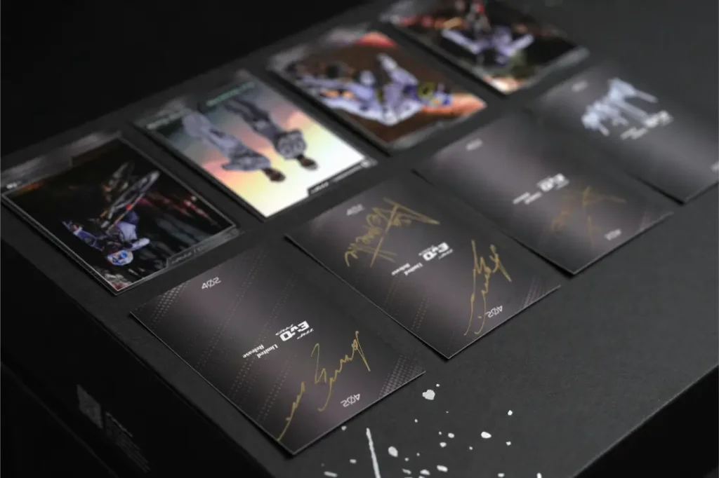 Varias cartas coleccionables, entre las que se incluyen las de la «Anniversary Edition» y las de la «edición limitada TRP EVO PRO», con imágenes de personajes y autógrafos en color dorado, se exhiben sobre una superficie oscura.