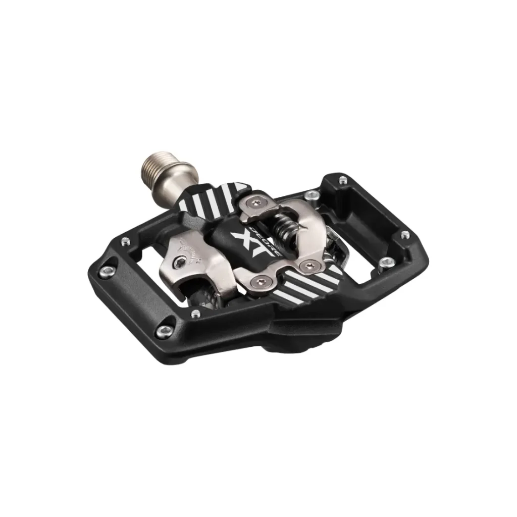 Un pedal de bicicleta sin clip, en negro y plateado, con plataforma integrada, ideal como pedales Trail Shimano DEORE XT SPD para XC y Gravel, mostrado sobre un fondo blanco.