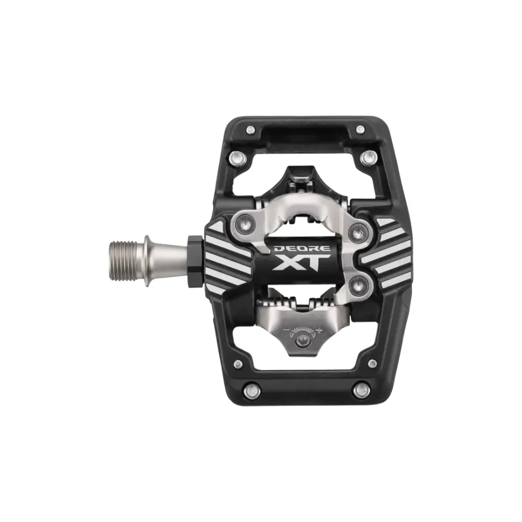 Un pedal Shimano DEORE XT con un diseño en negro y plateado, que cuenta con una plataforma y un mecanismo SPD central; ideal como pedales de trail o SPD para XC y gravel.