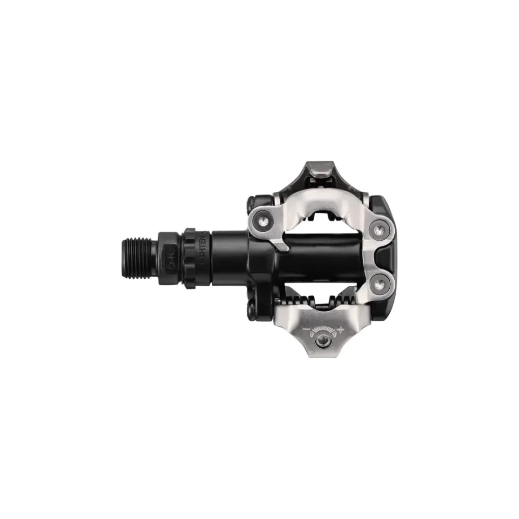 En un fondo blanco se muestra un pedal de bicicleta sin clip, en negro y plateado, con mecanismo SPD, ideal para salidas de XC Gravel con SPD.