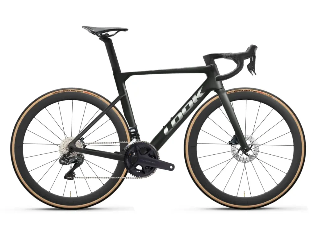 Una bicicleta de carretera LOOK 795 Blade RS 3 en negro mate, con neumáticos de flanco marrón claro, manillar de carretera, frenos de disco y el logotipo «LOOK» en el cuadro, mostrada en una vista de perfil lateral. Inspirada en el rendimiento total de Arma y en el espíritu de Nevers.