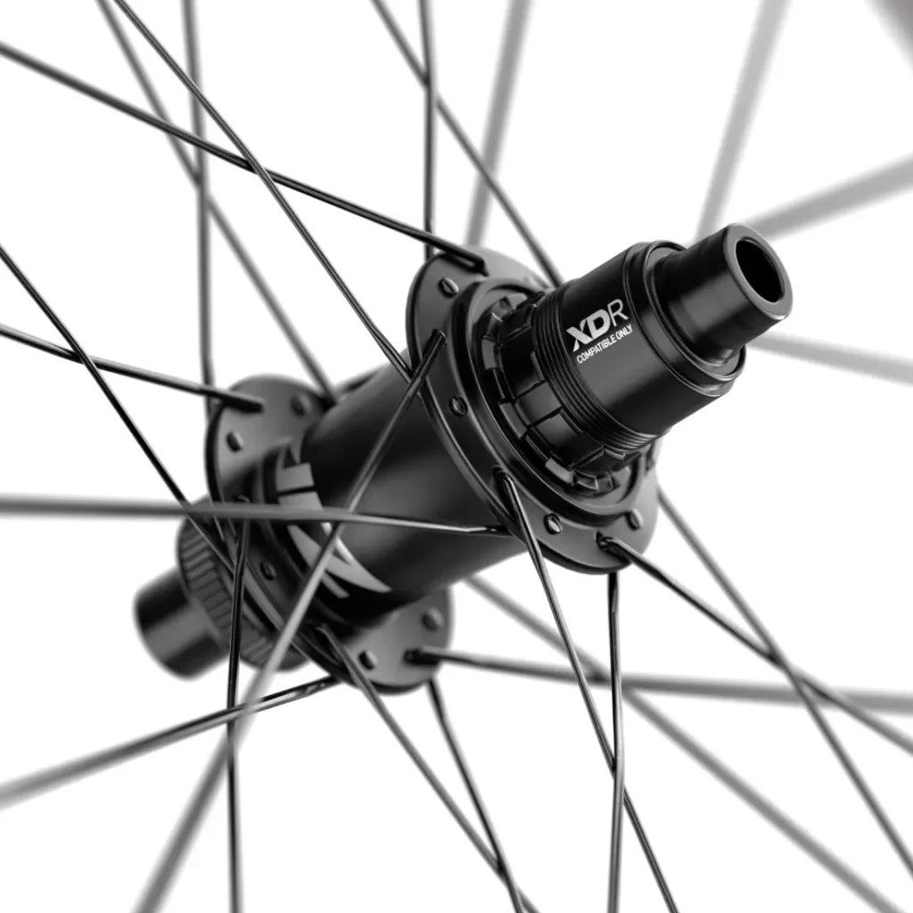 Primer plano de un buje negro de rueda de bicicleta Zipp 404 S con múltiples radios y una etiqueta que reza «XDR Compatible Only», conocido por su precio competitivo y su velocidad excepcional.