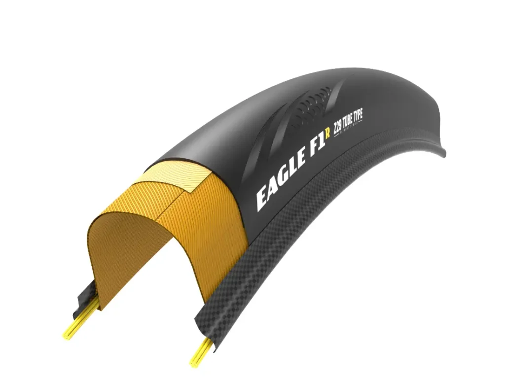 Sección transversal de una cubierta negra para bicicleta Eagle F1 en la que se aprecian las capas internas, incluidos los materiales estructurales amarillos y el diseño de la banda de rodadura, ideal para ciclistas que buscan velocidad y un rendimiento similar al de la Zipp 404 S a un precio competitivo.