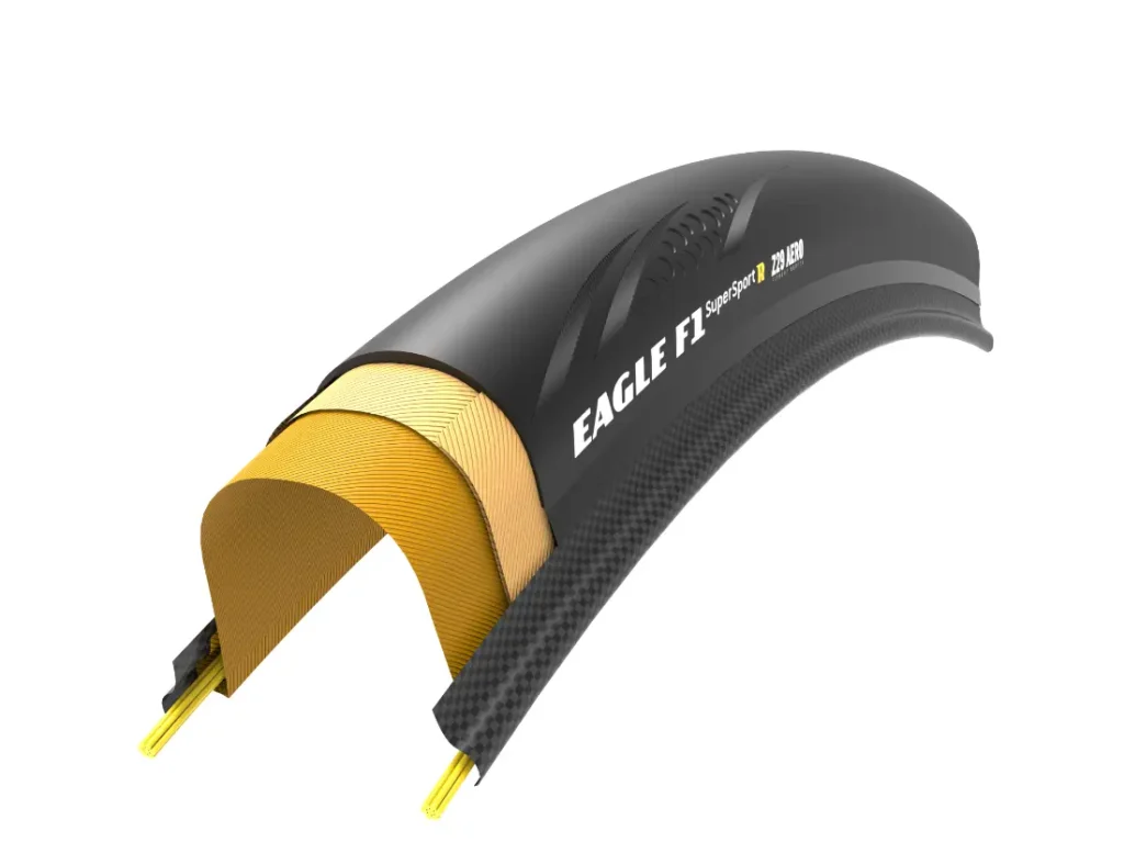 Se muestra una sección transversal de una cubierta de bicicleta denominada «Eagle F1 SuperSport», diseñada para la velocidad, con múltiples capas internas y materiales de fabricación, ideal para ruedas como la Zipp 404 S.